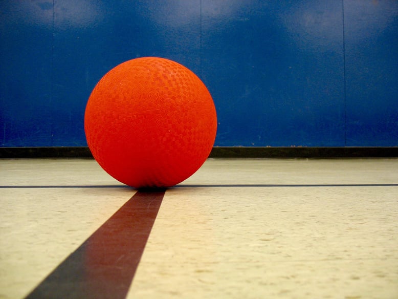 red playground ball resting on black lines